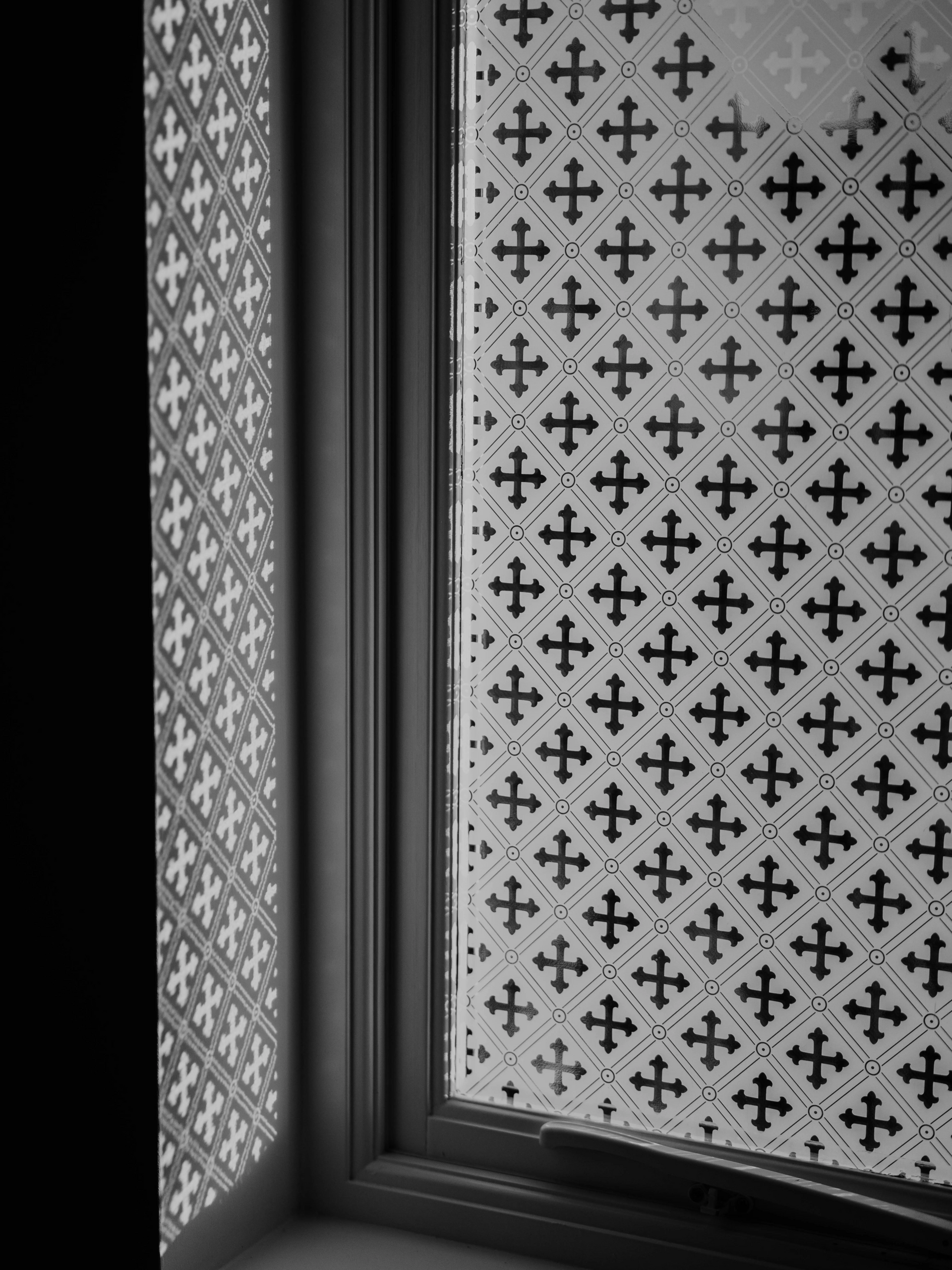 Decorative window frame with frosted patterned glass panels in black and white