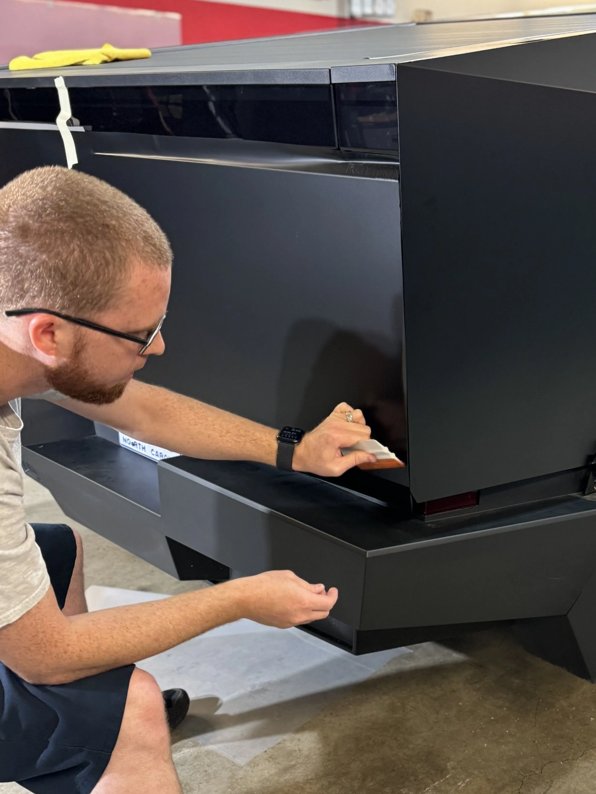 Person opening a black equipment cabinet drawer in an indoor workshop