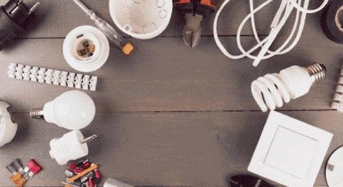 Hay muchos tipos diferentes de bombillas y herramientas sobre la mesa.