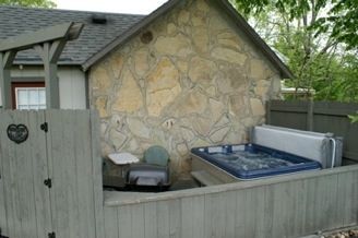 Backyard with a stone shed, fenced hot tub, and patio furniture