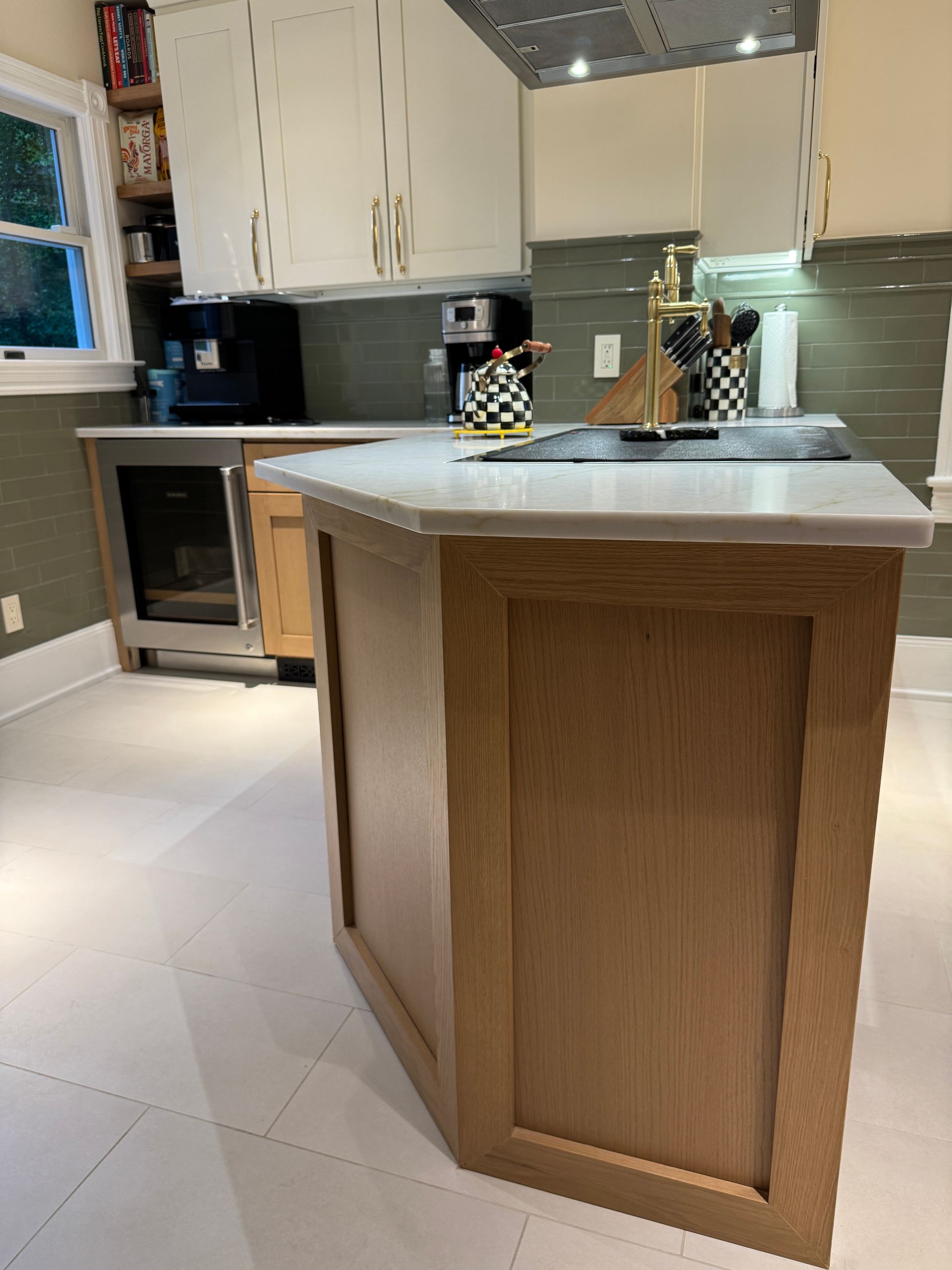 Modern kitchen with a wooden island, white cabinets, and a marble countertop