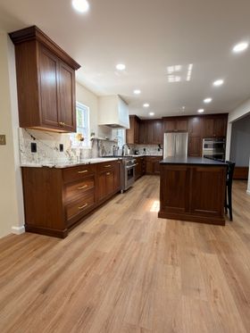 Gray kitchen cabinets with a light countertop and tile backsplash.