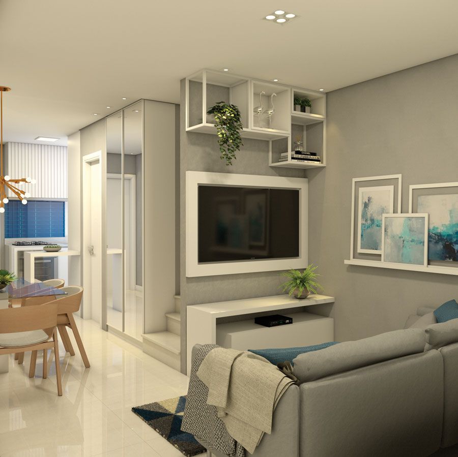 Uma sala de estar moderna com uma TV montada em uma parede cinza, prateleiras brancas, um sofá cinza claro e uma área de jantar adjacente.