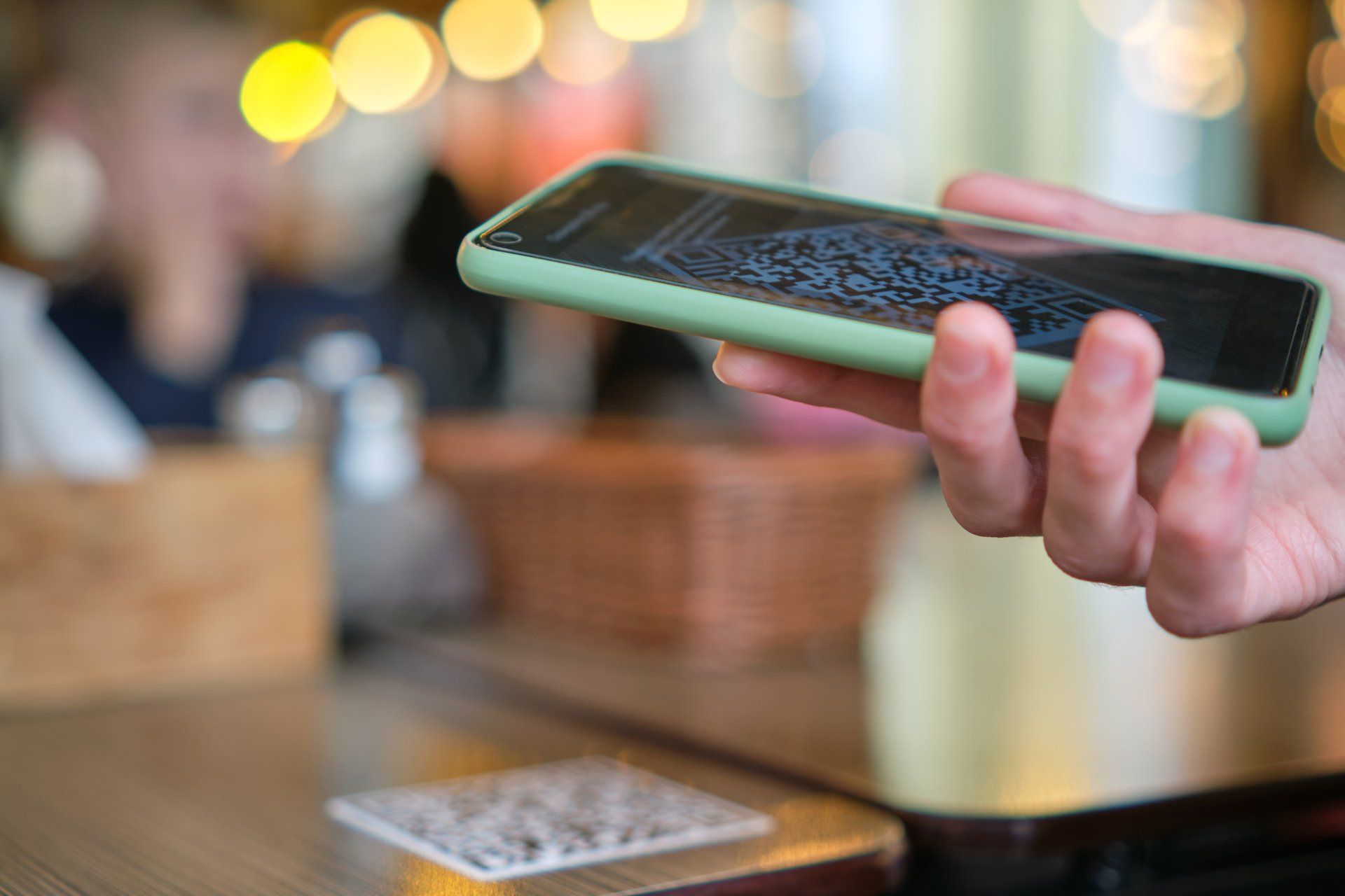 Primer plano de la mano del invitado que pide comida en el restaurante mientras escanea