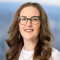 A portrait of Cindy Malota, Accounts Payable at CONNSTEP, with long brown hair, glasses, and a white top, smiling at the camera.