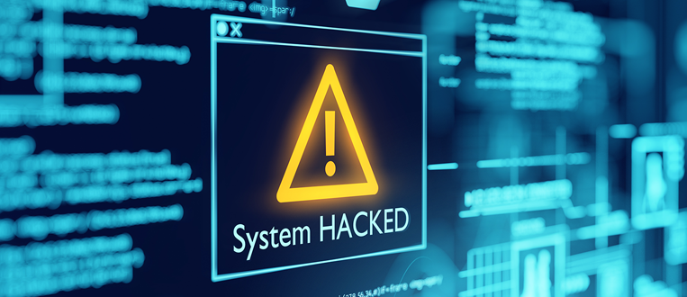 System hacked warning on a computer screen. A yellow triangle with an exclamation mark appears above the words
