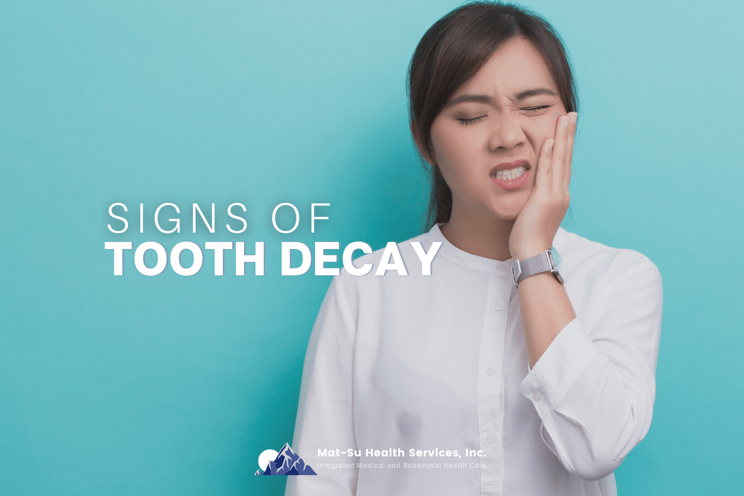 woman holding side of her mouth in pain