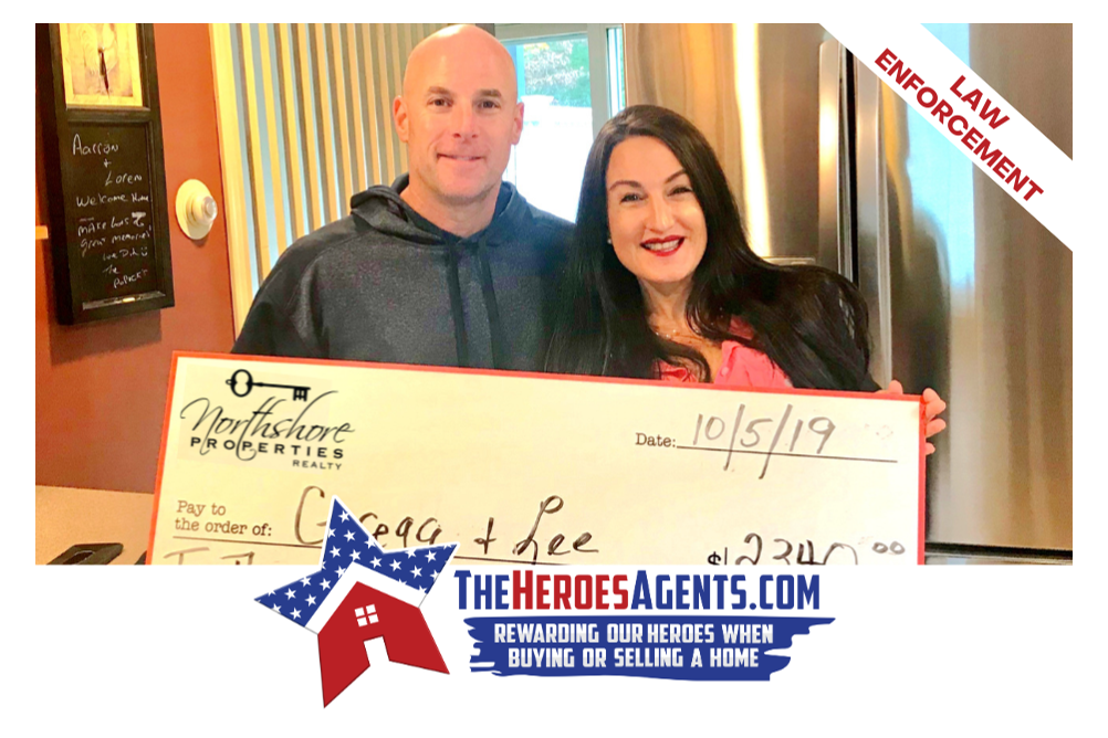 A man and a woman are holding a large check.