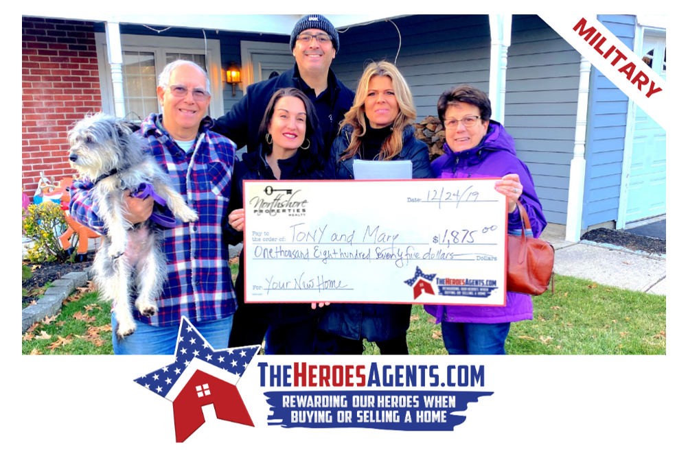 A group of people holding a check in front of a house.