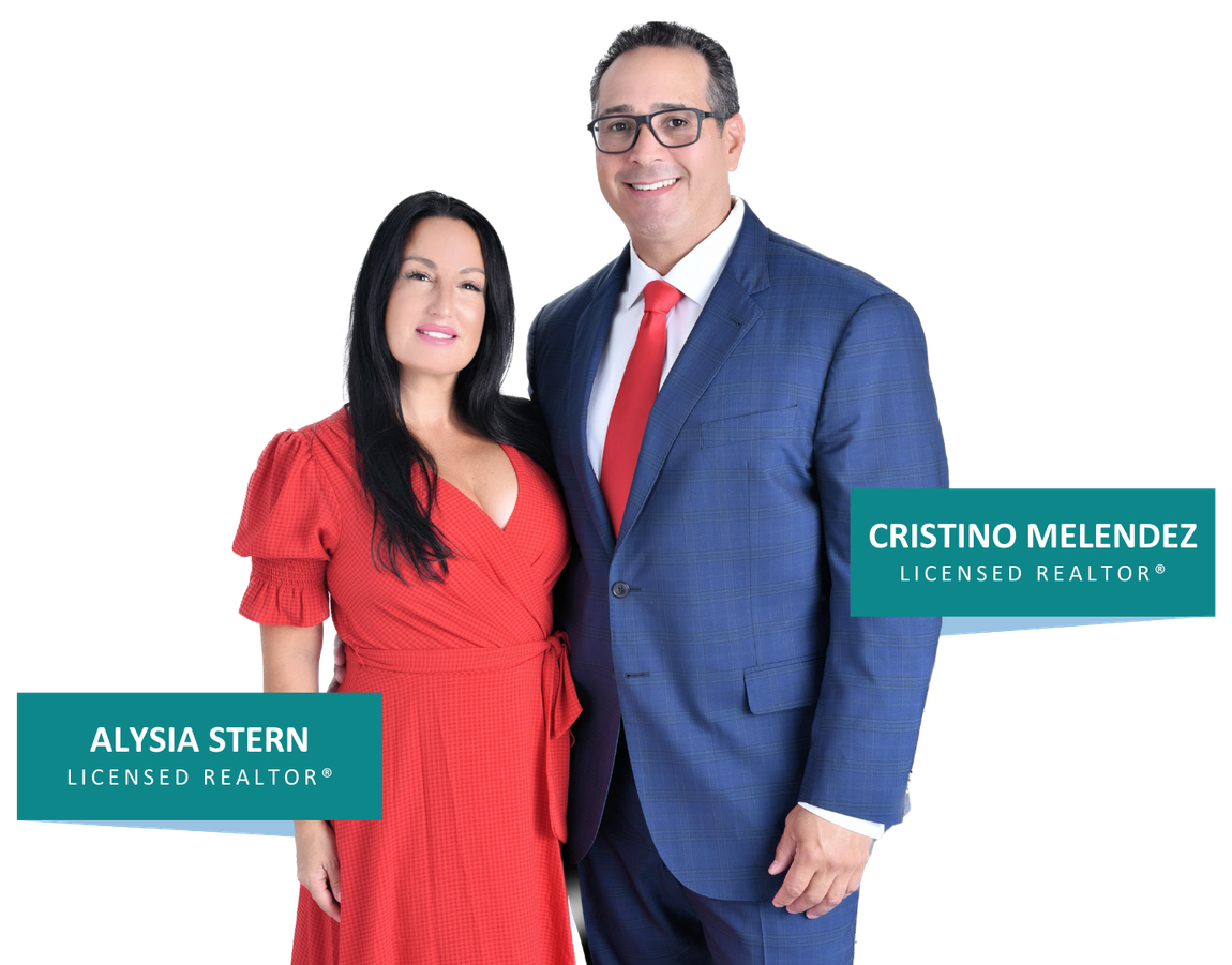A man in a suit and tie stands next to a woman in a red dress.