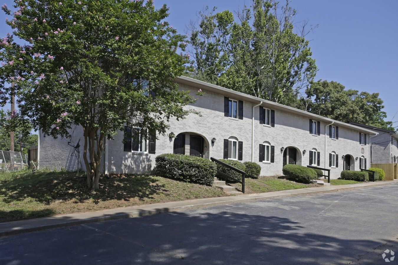 A white apartment building with trees in front of it