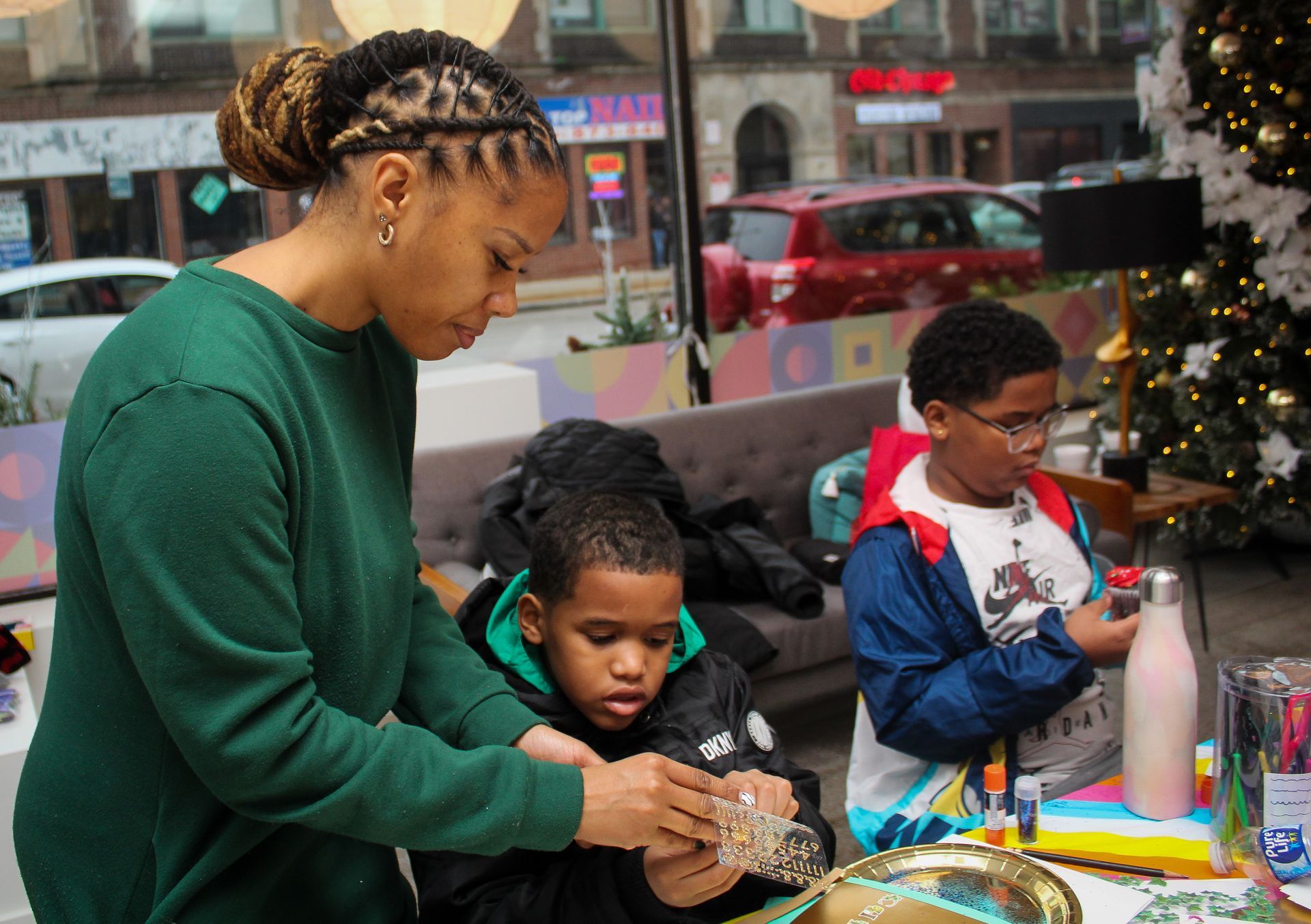A woman is helping children with a craft project.