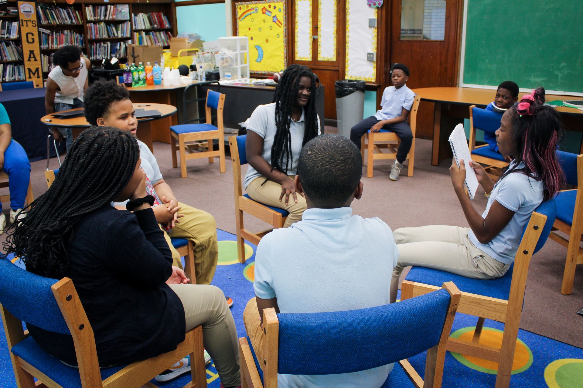Children in classroom engaging with one another in a circle.