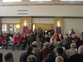 Crowd seated in a hall watching a group performing at the front