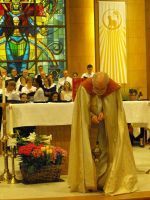 Clergy in white and gold robes bow before an altar in a stained-glass church.