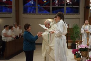 Woman receives communion from clergy during a church ceremony
