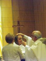 Clergy performing a forehead blessing during a church ceremony