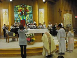 Church service with altar, stained-glass window, clergy, and congregation during a ceremony