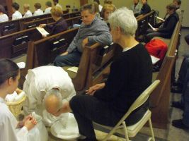 People seated in a church pew, one person leaning forward in prayer.