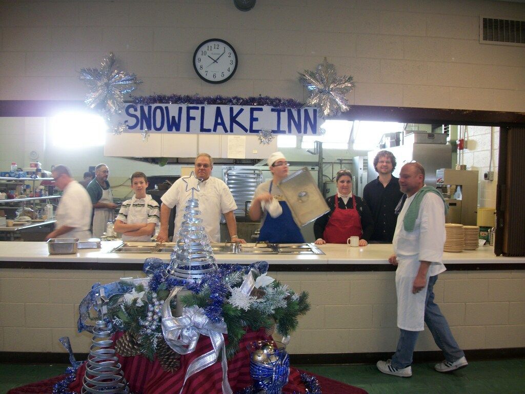 Bakery counter with staff posing under a Snowflake Inn sign and a decorated holiday display