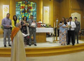 People standing in a church sanctuary near an altar and stained-glass window during a ceremony