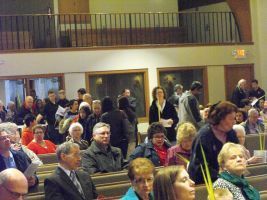 Audience seated in a church or auditorium, listening during a gathering