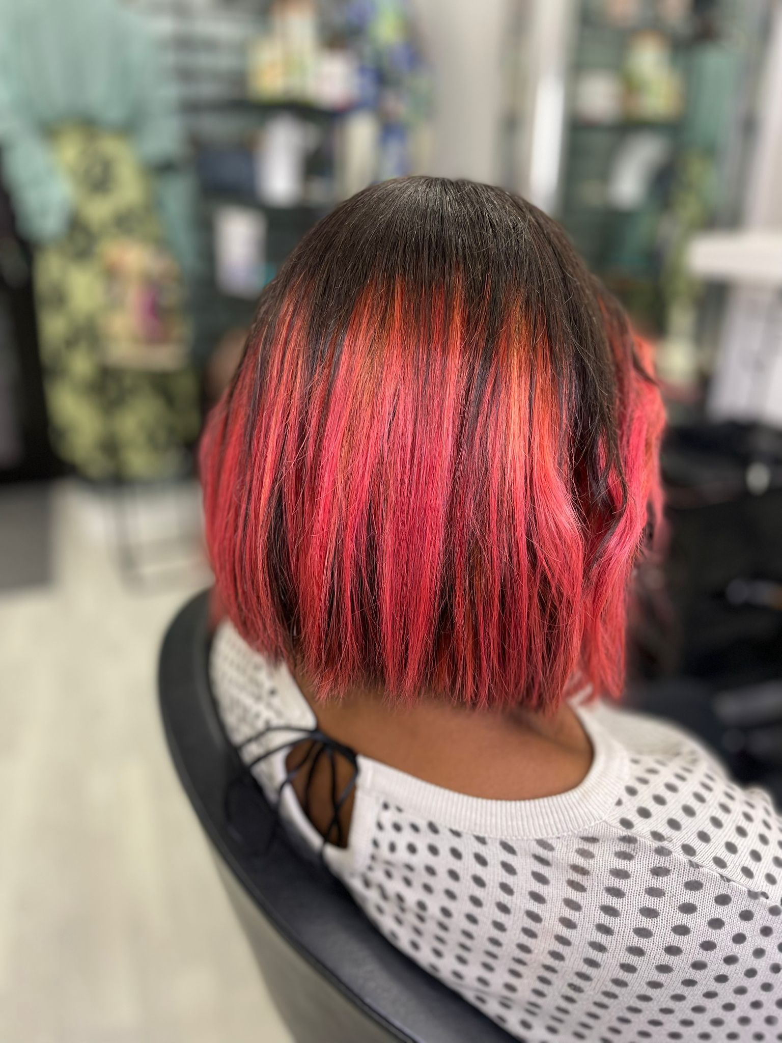 Una donna con i capelli rossi è seduta su una sedia in un salone.