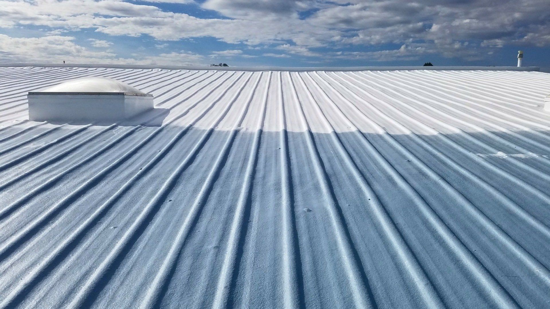 A blue and white roof with a skylight on top of it.