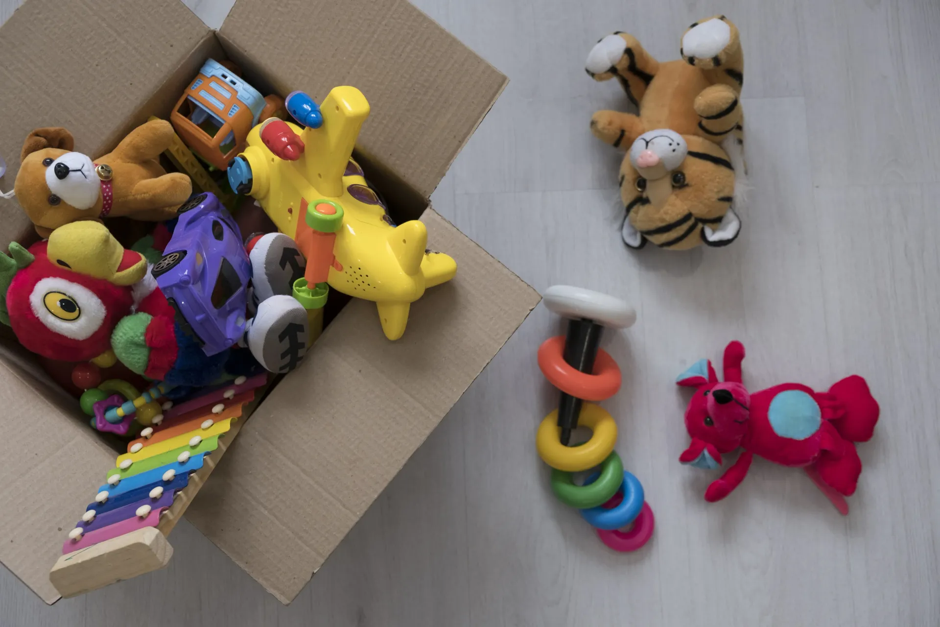 Una scatola di cartone piena di tanti giocattoli per bambini.