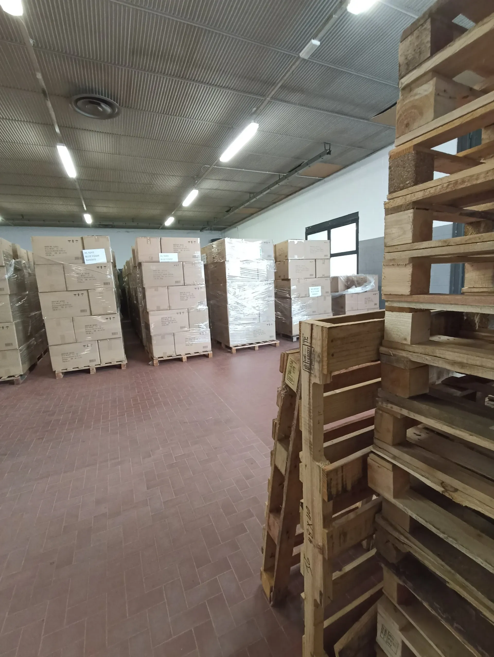 Un magazzino pieno di scatole e pallet di legno.