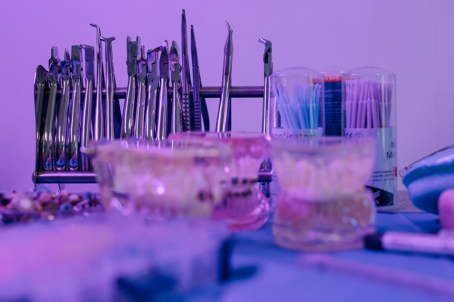 Purple-lit tabletop with stacked metal dish racks and glass cups