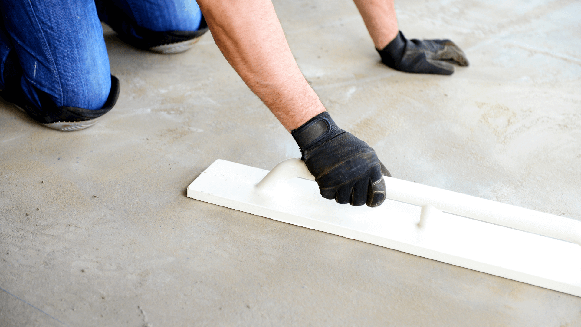 man smoothing down concrete garage floor