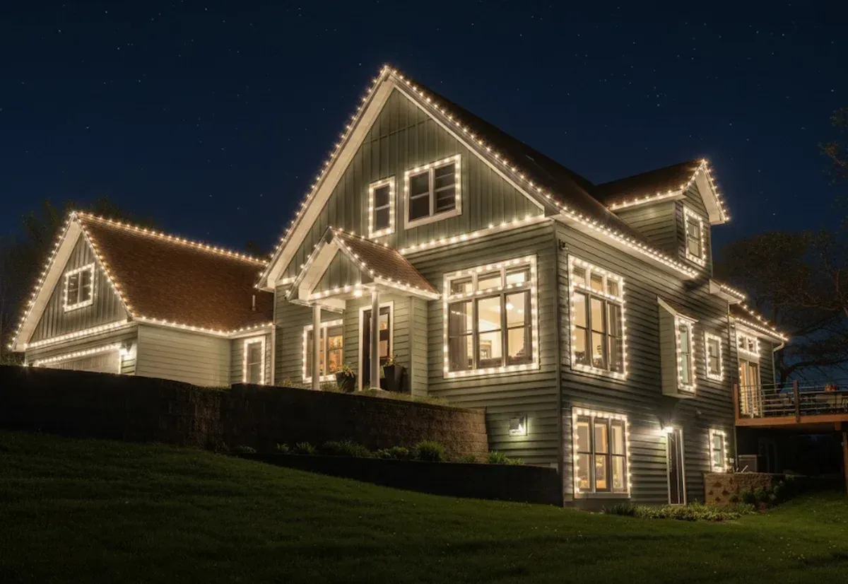 House decorated with white Christmas lights at night.