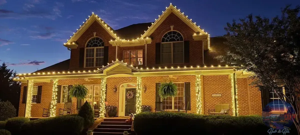 Brick house decorated with white Christmas lights.