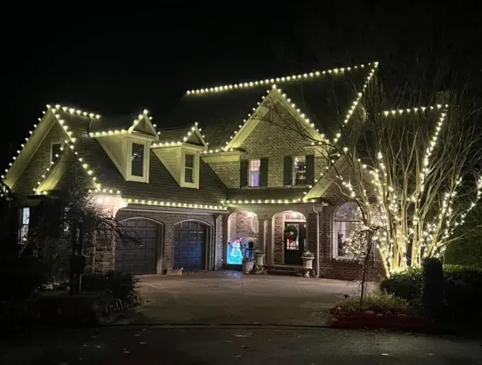 House decorated with white Christmas lights at night.