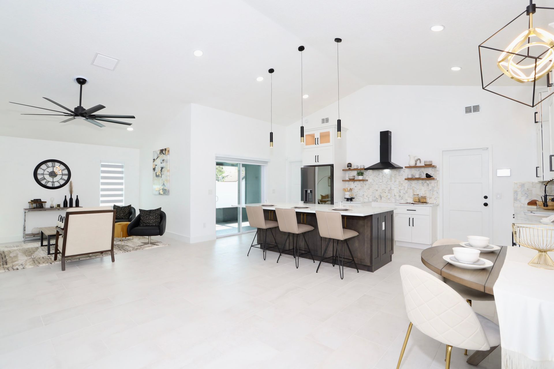 Modern white and gray living room with red accents, black coffee table, and open staircase