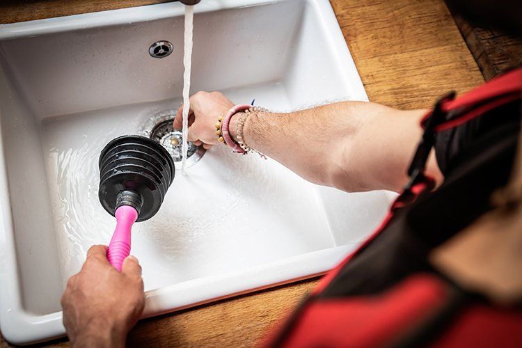 Plumber Fixing Kitchen Sink — Wilmington, DE — A.J. Dauphin & Son Plumber Fixing Kitchen Sink — Wilmington, DE — A.J. Dauphin & Son
