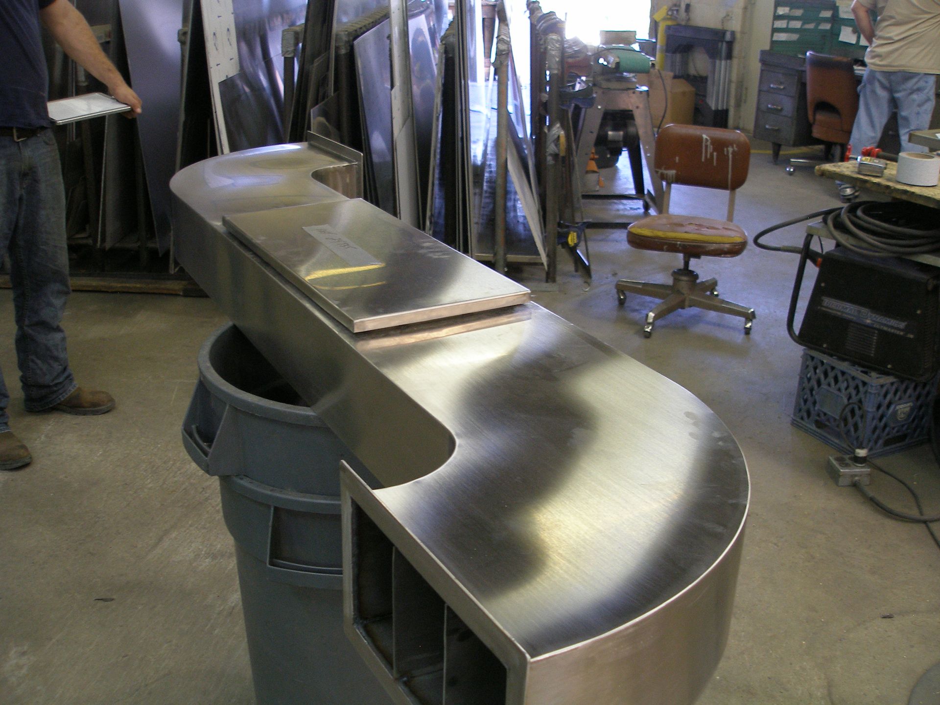 A man standing next to a stainless steel counter top