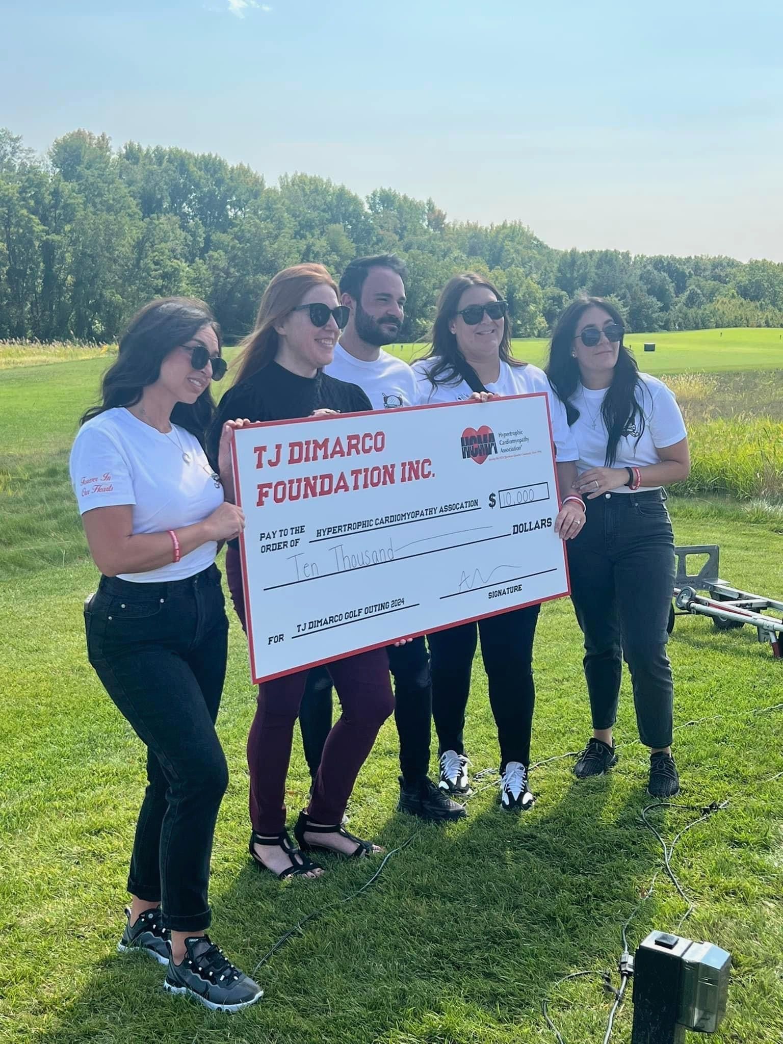 5 people holding a large check to the HCMA from the TJ Marco Foundation INC