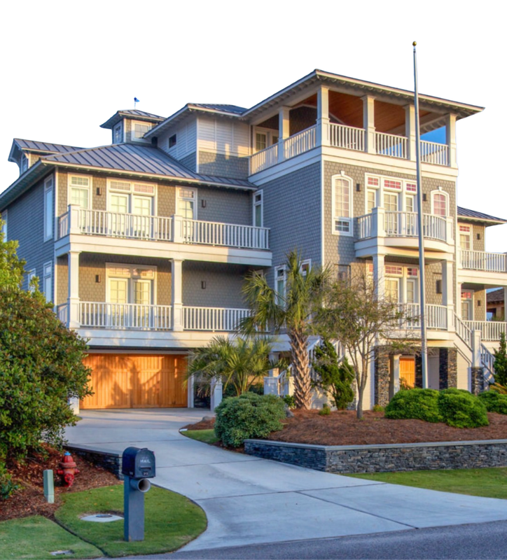 Large beige multi-story house with balconies, garage, and landscaped front yard along a curved driveway