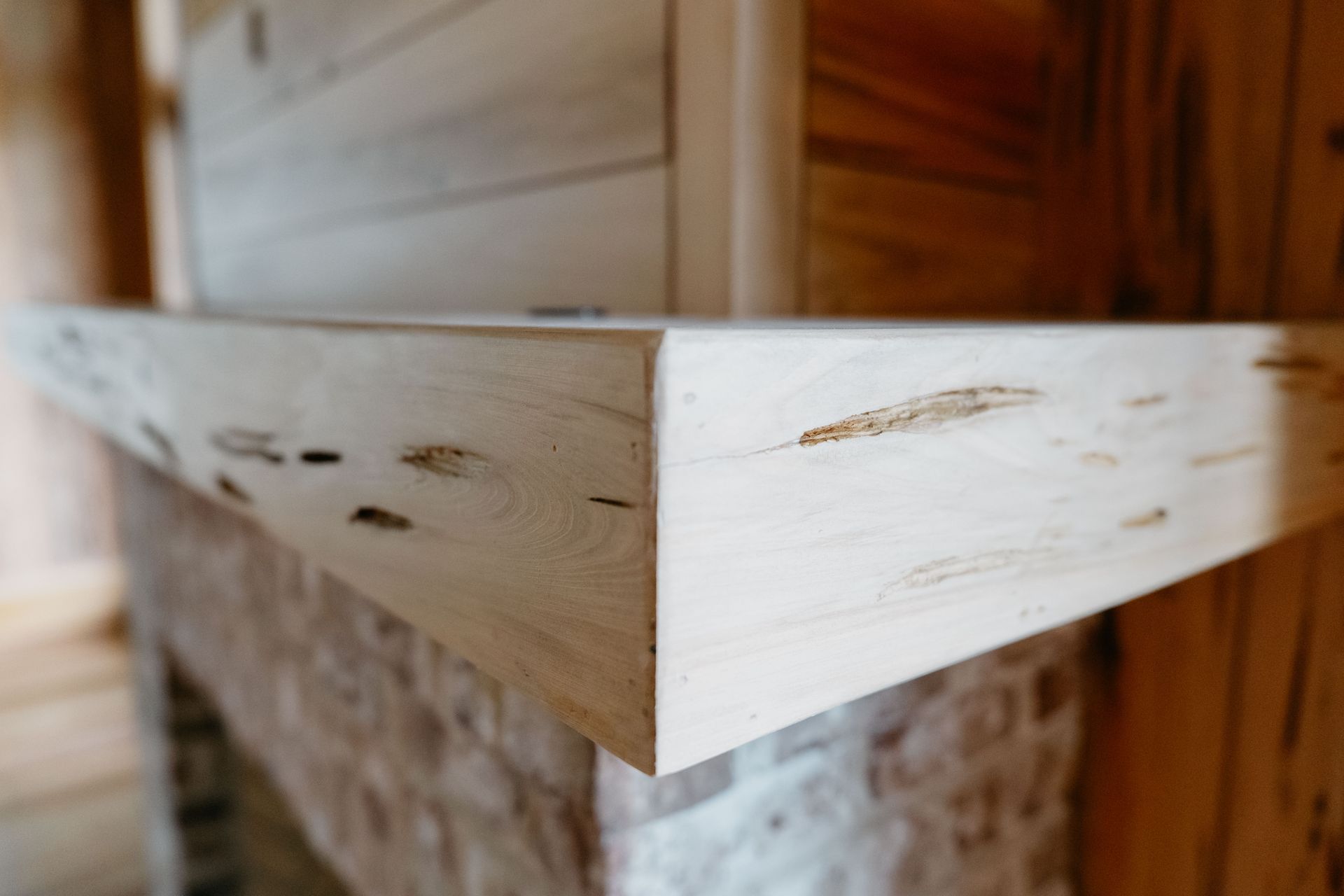 Close-up of a white wooden shelf corner with visible scratches and a stone base underneath