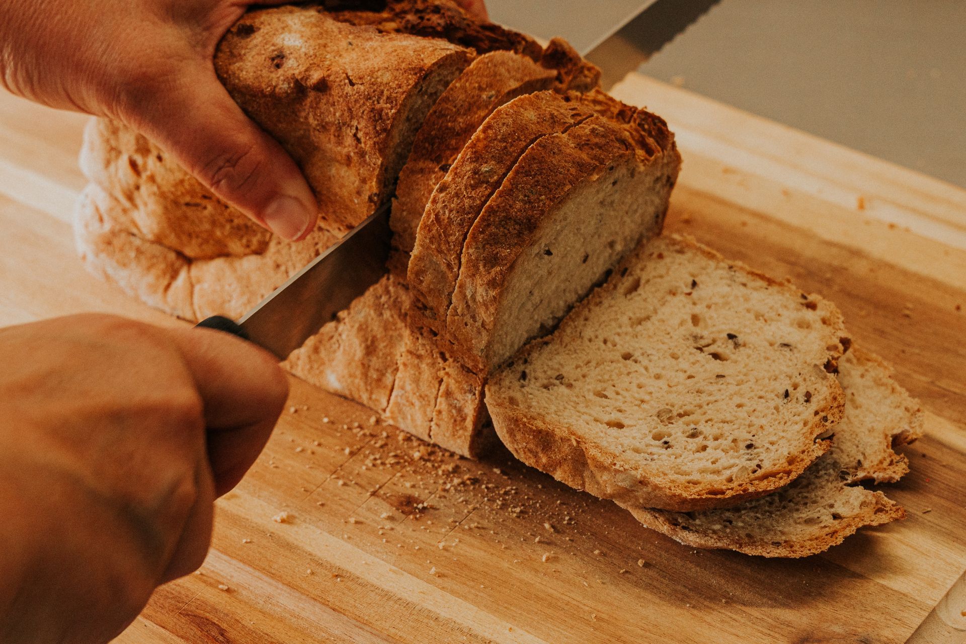 Una ciotola di cubetti di pane cotti accanto a mucchietti di farina bianca con uova rotte sopra.