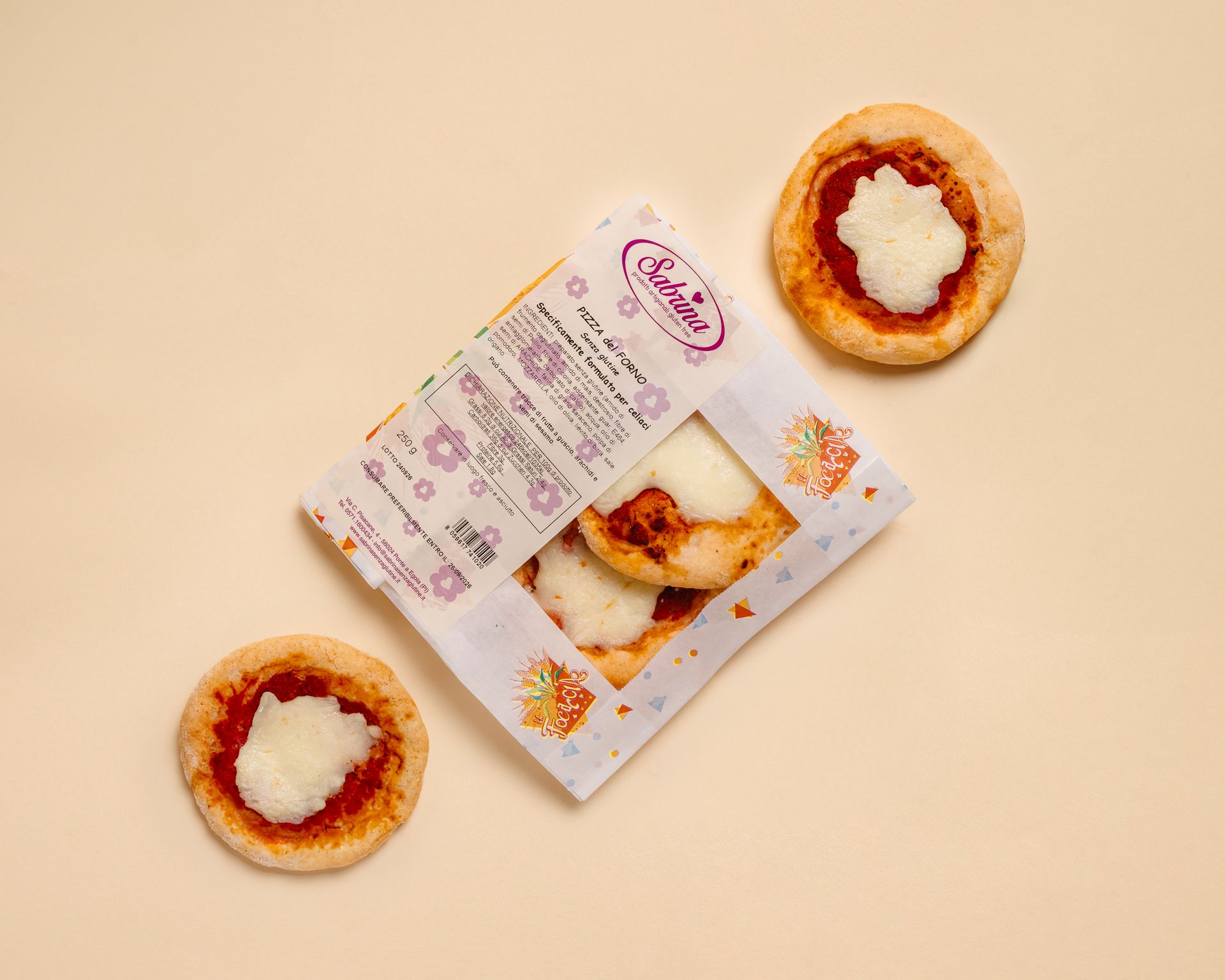 Assortimento di biscotti e pasticcini confezionati in una scatola regalo di marca su sfondo beige.