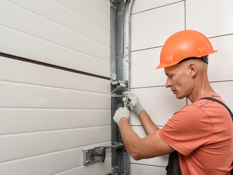A man in an orange hard hat is engaged in garage door repair in Winnemucca, NV, reflecting dedication to quality service. A man in an orange hard hat is engaged in garage door repair in Winnemucca, NV, reflecting dedication to quality service.