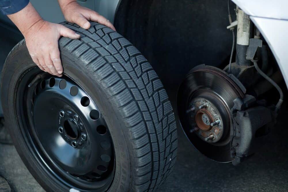 A Person is Changing a Tire on a Car — Aspire Diesel In Moura, QLD