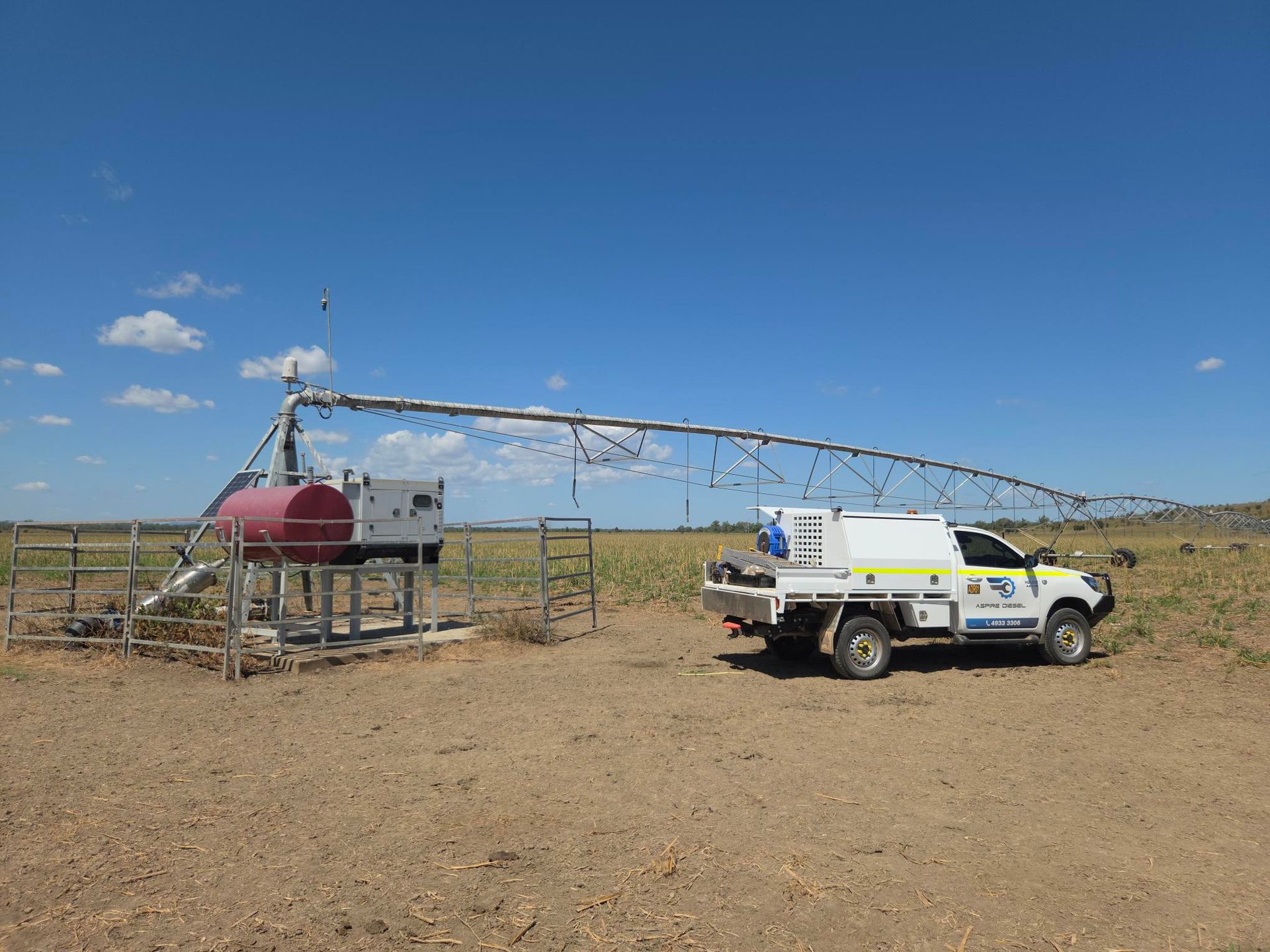 White Utility Truck Beside A Metal Pump And Red Tank In A Dry Rural Field Under A Clear Blue Sky — Aspire Diesel In Gracemere, QLD
