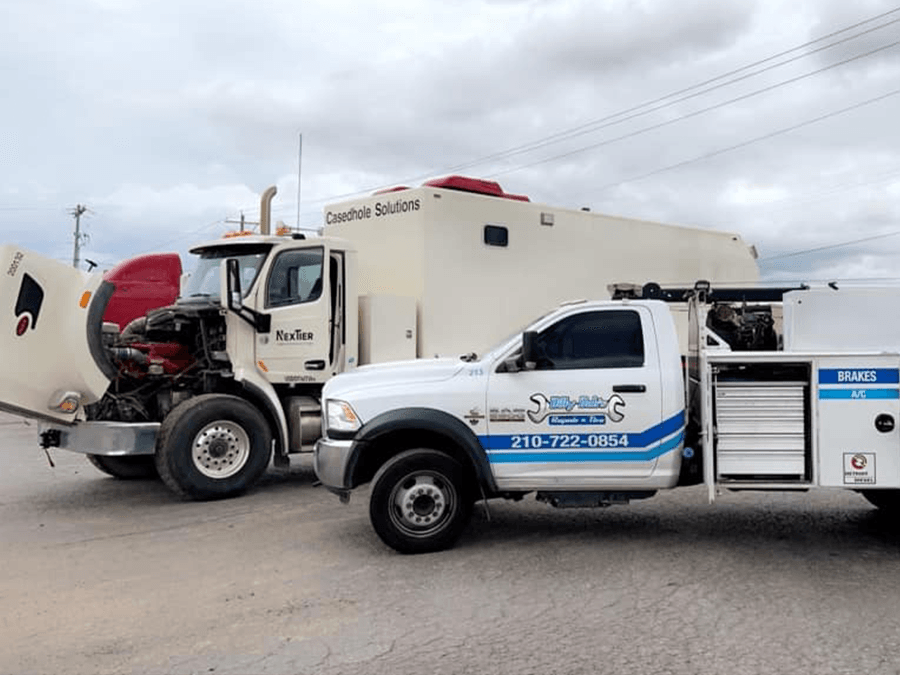 Two trucks are parked next to each other on the side of the road.