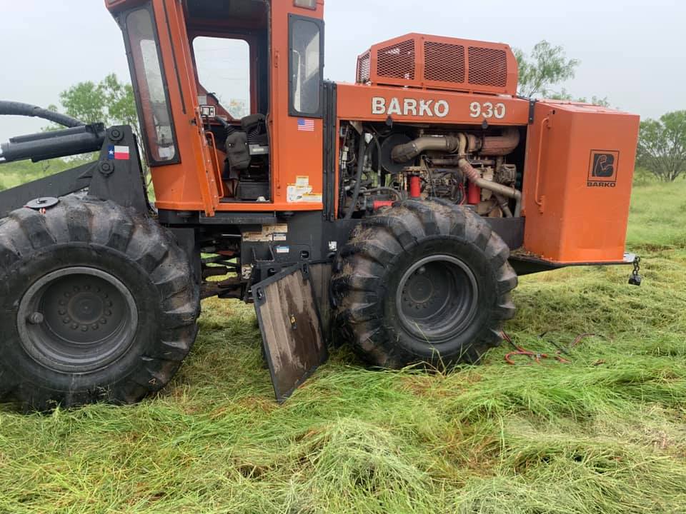 A large orange tractor is parked in a grassy field.