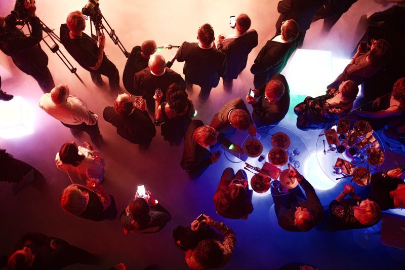 Comprehensive 6-page Corporate Event Planning Checklist PDF to create a successful and well-organized event laid out in detail from start to finish. group of people in professional attire are gathered around tables with plates of food