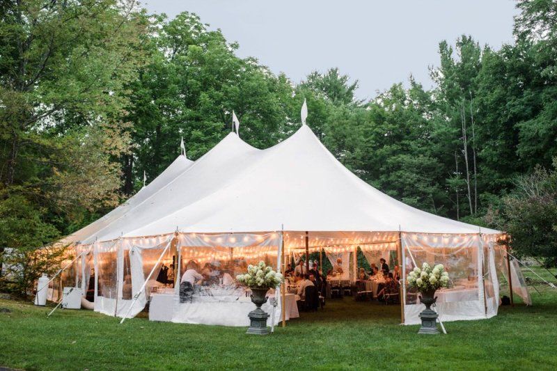 Explore Zohar Production's Guide to Tent Sizes, featuring expert insights and tips on selecting the perfect tent size for your wedding or event. a large white tent is set up for a wedding reception